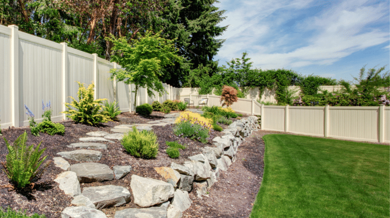 Professional hardscape design with stone pathway and white vinyl fencing by Black Pine Hardscapes