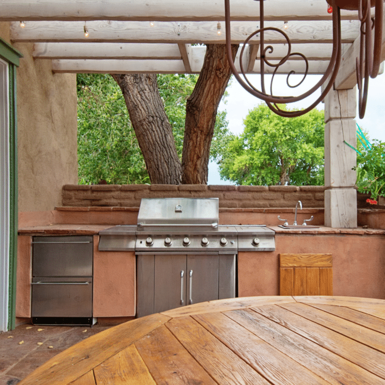 Rustic outdoor kitchen with stainless steel grill, sink, and wooden features crafted by trusted outdoor kitchen contractors.