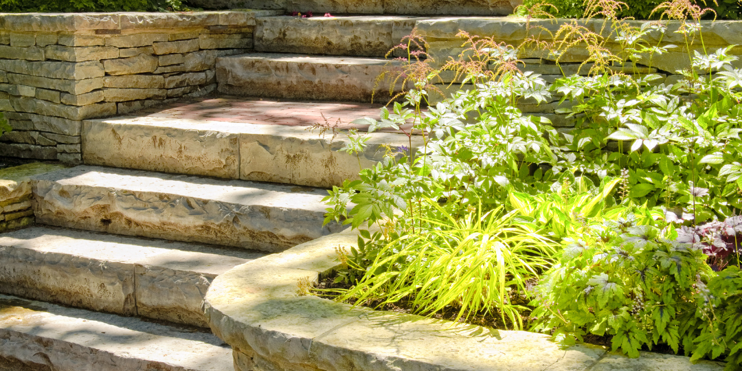 Custom stone stairway with integrated landscaping by Black Pine Hardscapes