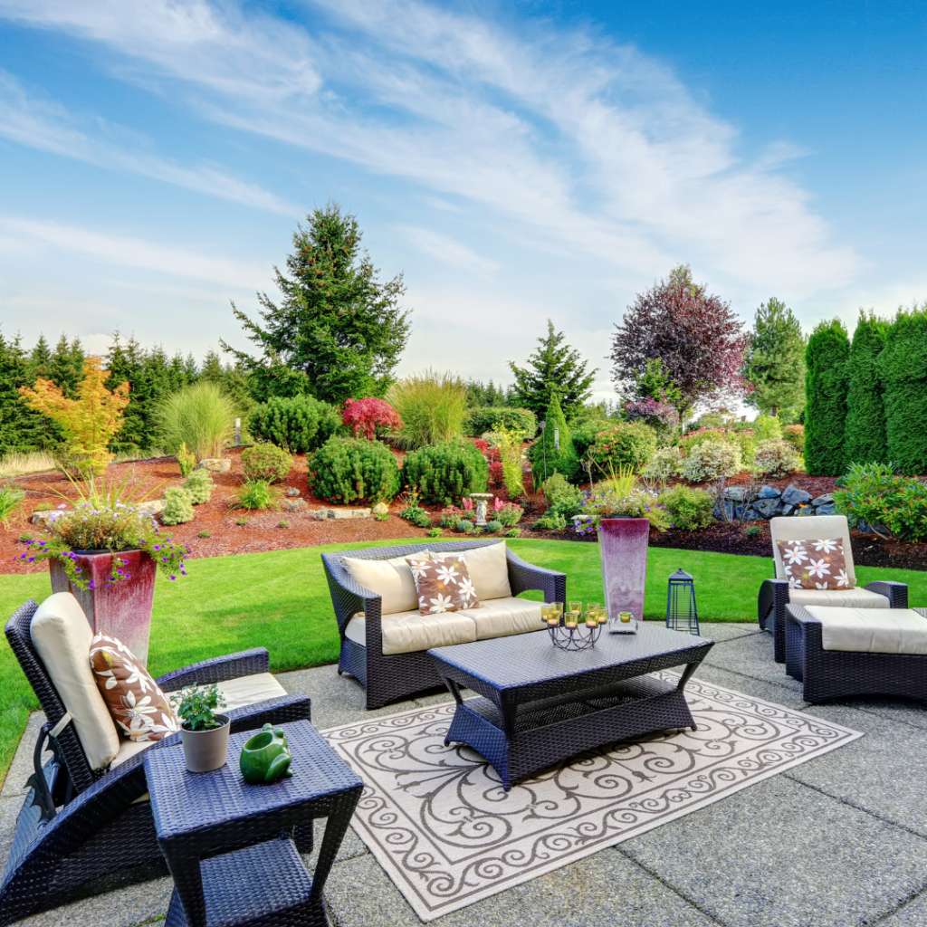 Luxurious outdoor patio with comfortable seating surrounded by professional landscaping