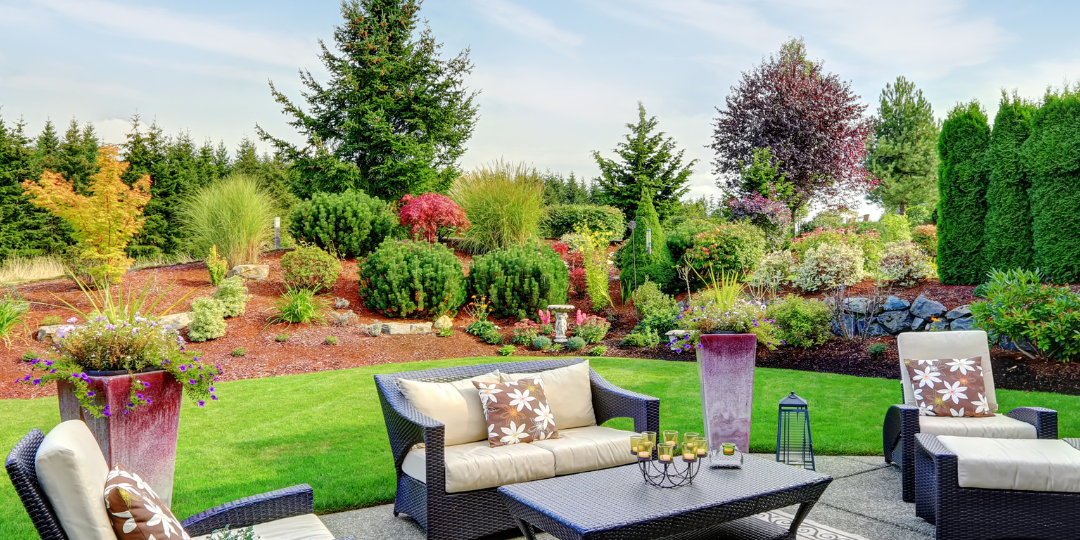 Luxurious outdoor patio with comfortable seating surrounded by professional landscaping