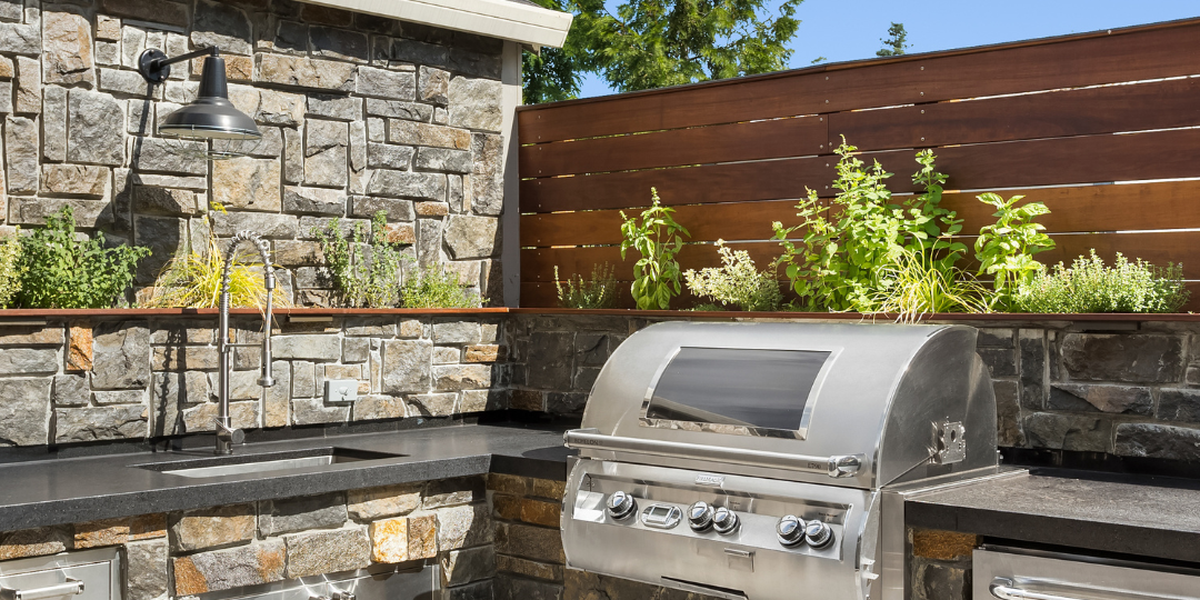 Custom outdoor kitchen with stone countertops and built-in grill