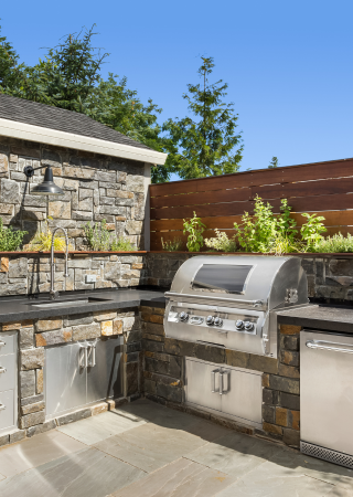 Custom outdoor kitchen with stone countertops and built-in grill